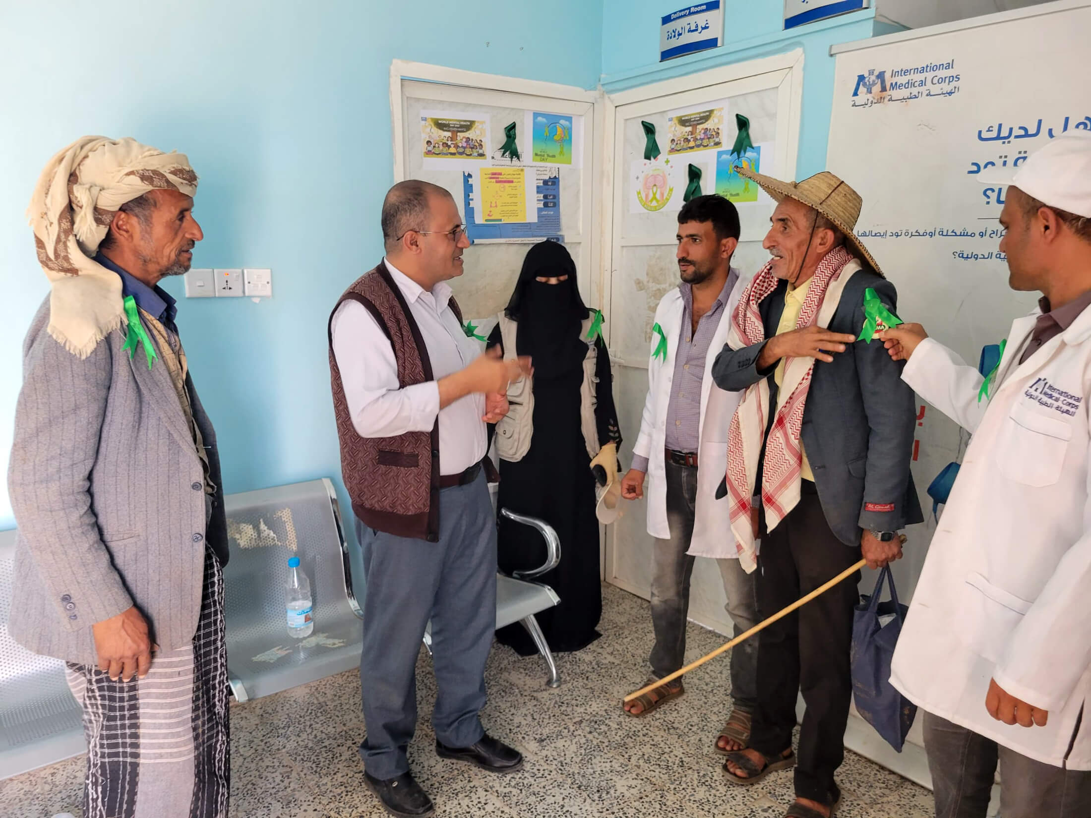 Health workers at the Al Karabah health unit in Ibb governorate speak to community members about the importance of mental health, giving them green ribbons to wear to show their support for mental health.