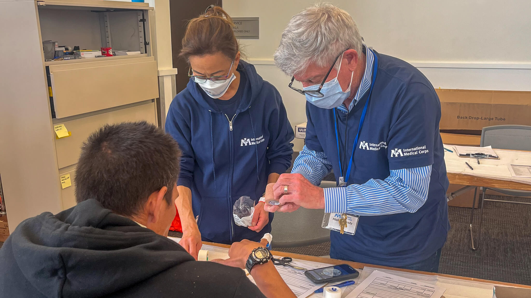 An International Medical Corps doctor and nurse fix a splint for a shelter resident at the Pasadena Convention Center.