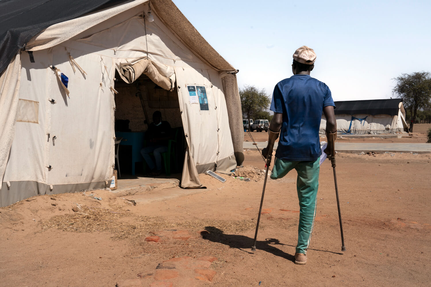 A patient whose leg was amputated after he was shot in April 2023 goes to pick up his prescription medication at the pharmacy at our clinic in Dougui camp.