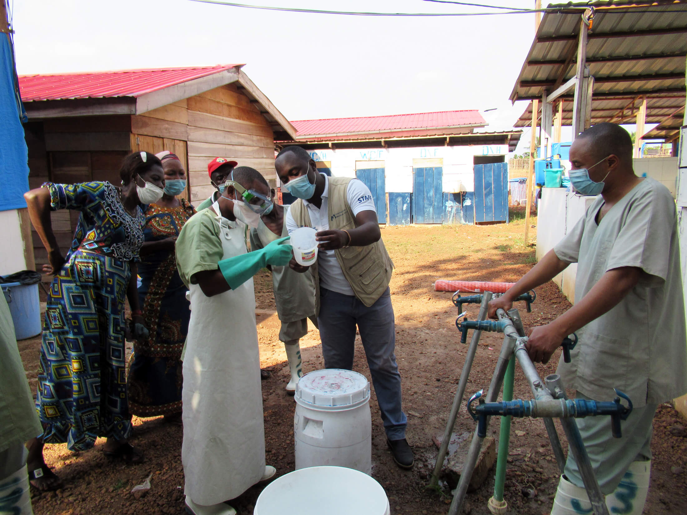 International Medical Corps staff show health workers at the Wangata Ebola Treatment Center in Equator, DRC, how to make the chlorine solution used to sanitize medical equipment and treatment areas.