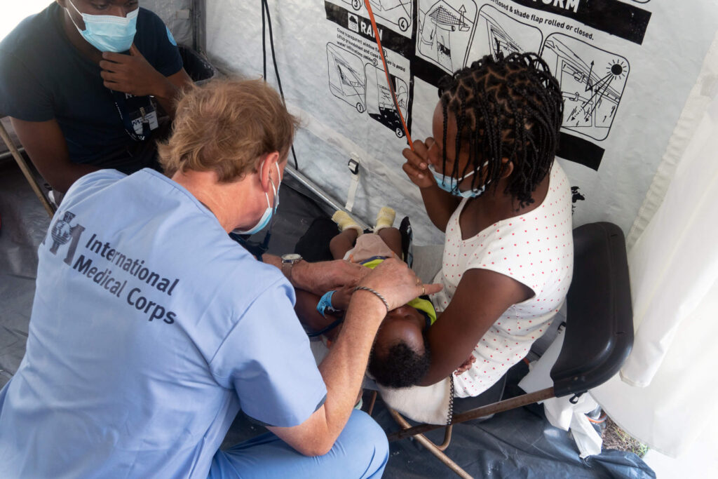 Volunteer Dr. Thomas Bernadzikowski performs a checkup on a baby during our 2021 Haiti response.
