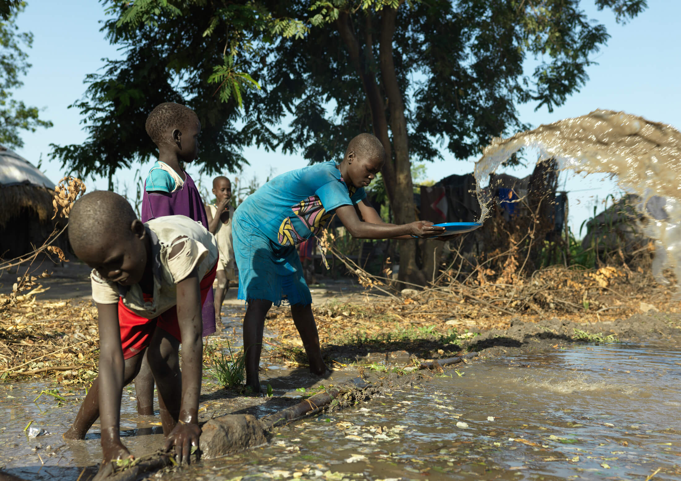 Villagers in Dolieb, South Sudan, try to remove water after burst dikes had flooded their homes.