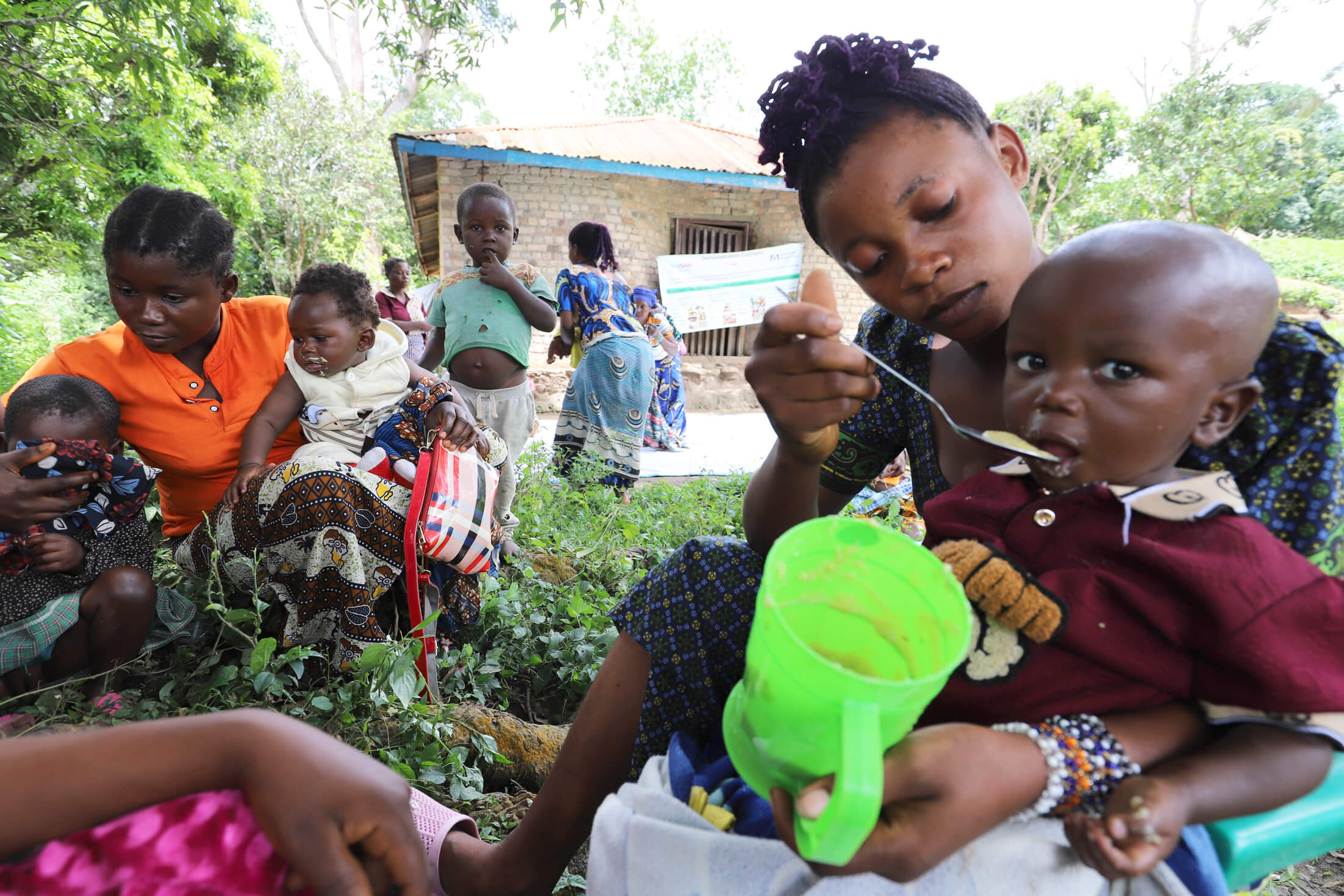 A mother feeds her child nutritious food she learned to prepare at our cooking demonstration.