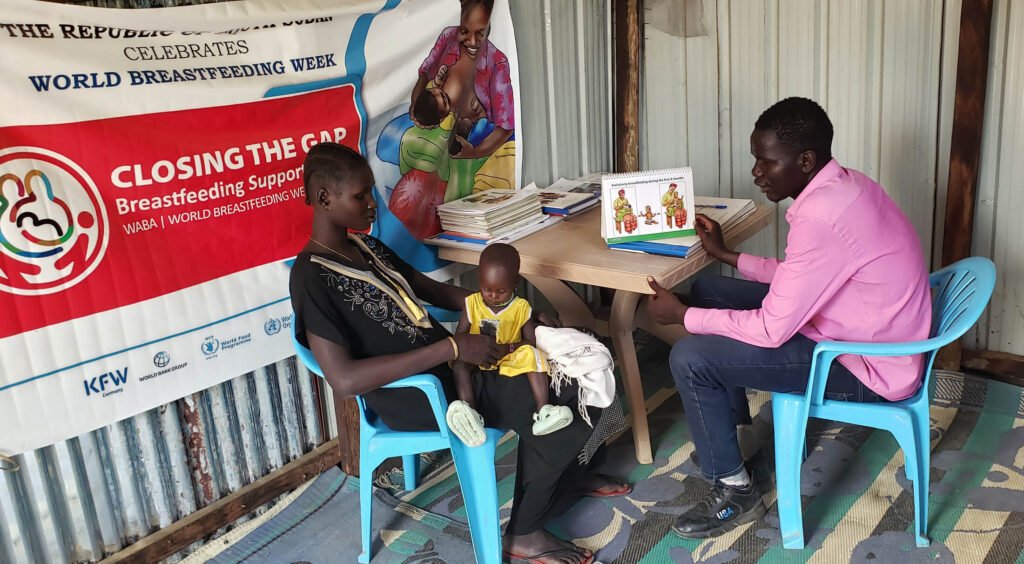 Nyaleah receives training in healthy feeding techniques from Nutrition Assistant John Gatliah.