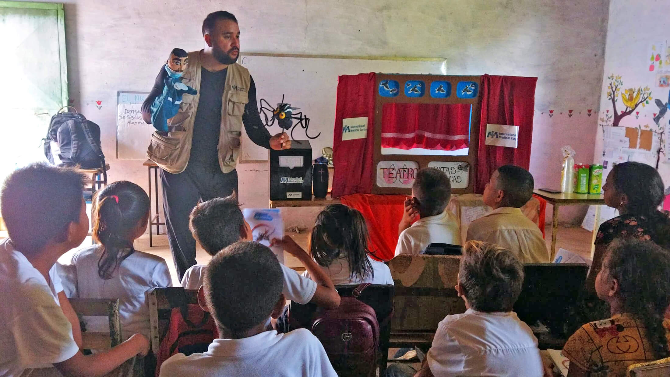 International Medical Corps staff members take part in an educational puppet show at a community school.