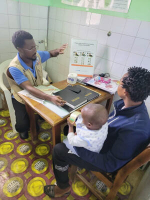 An International Medical Corps Nutrition Assistant examines Ezekiel during discharge from the nutrition programme.