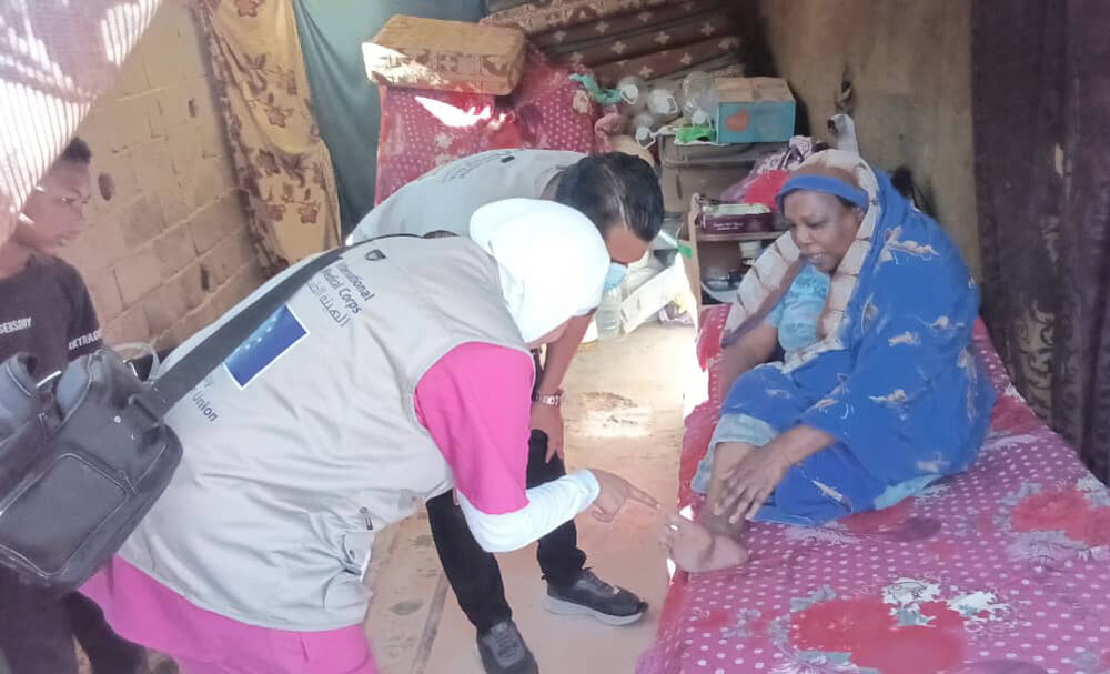 Staff examine Saadia’s infected foot during a medical consultation with an International Medical Corps mobile medical team in February 2025.