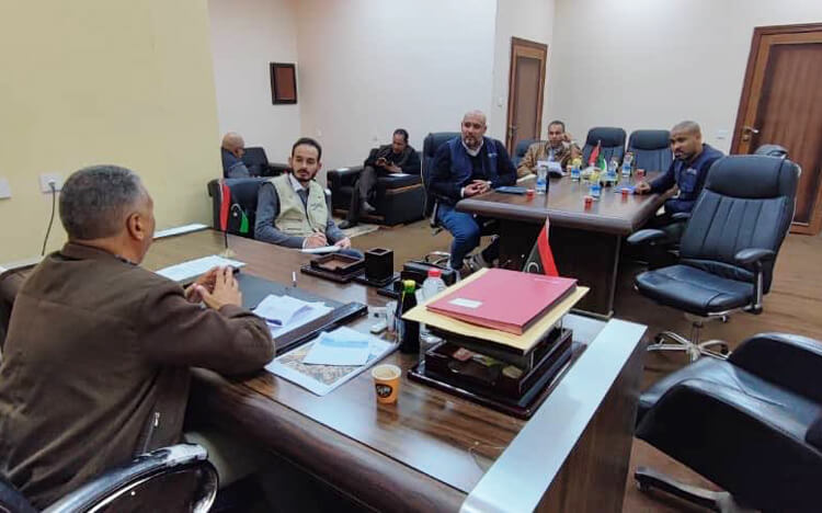 Country Director Talal Burnaz (centre; tan vest) and other International Medical Corps team members meet with local government officials in Kufra.