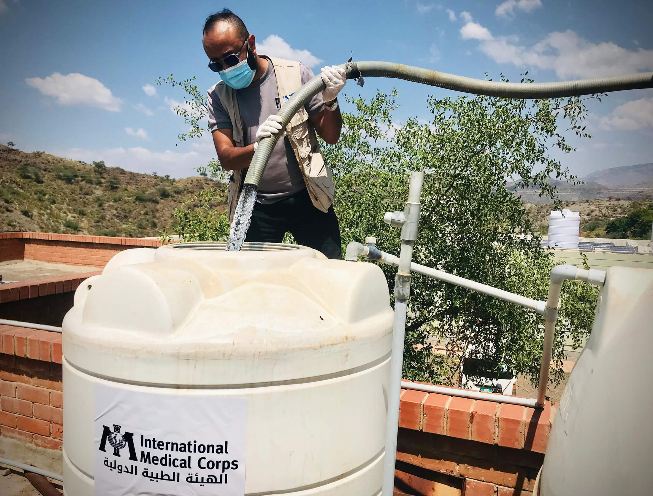 A staff member fills the barrel with water from our truck.