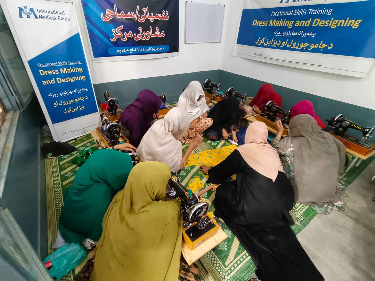 A group of women make dresses at a vocational-skills training programme in Pakistan offered by International Medical Corps to Afghan refugee women, who leveraged the skills they learned to support their families.
