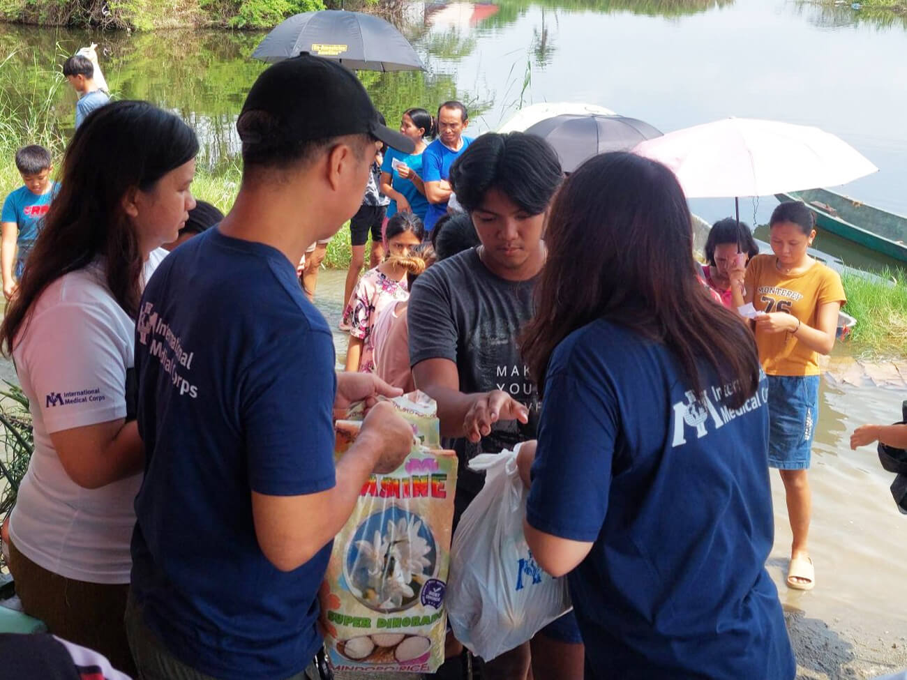 International Medical Corps team members distribute food to flood-affected families.