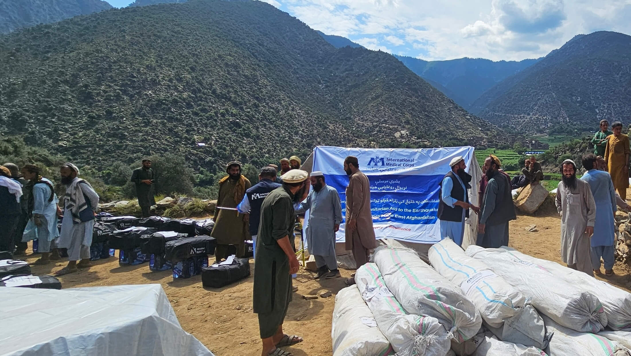 International Medical Corps staff members distribute tents, winterisation kits and drinking water at a distribution site in Andar Lachak village.