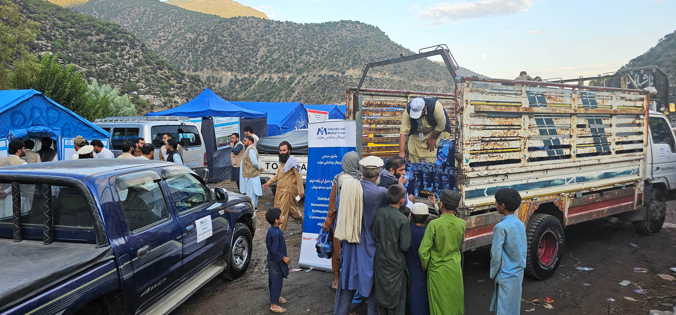 International Medical Corps staff members distribute clean water to earthquake-affected families in Kunar province.