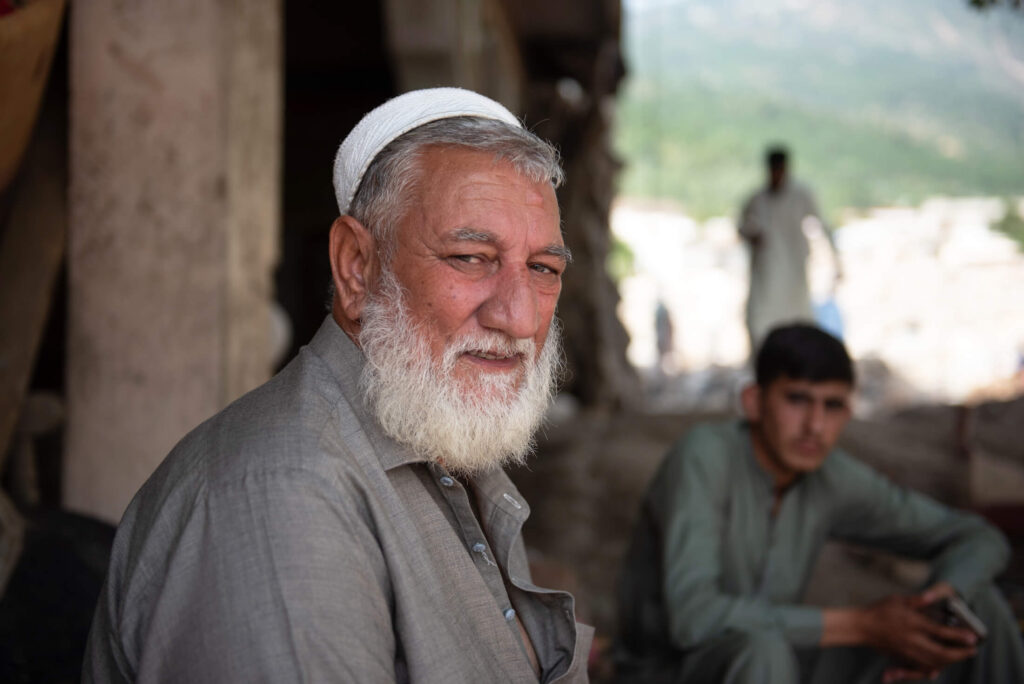 Farooq Khan sits outside his house, which was destroyed by the flooding.