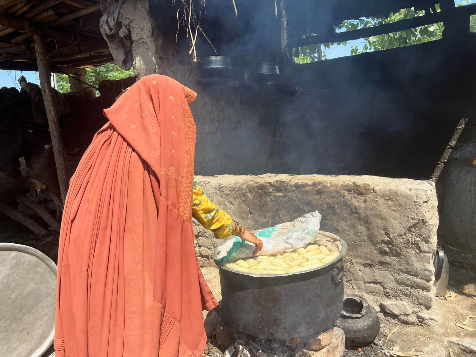 Zareen cooks corn that her brother will sell in the local marketplace, bringing much-needed income for their family.