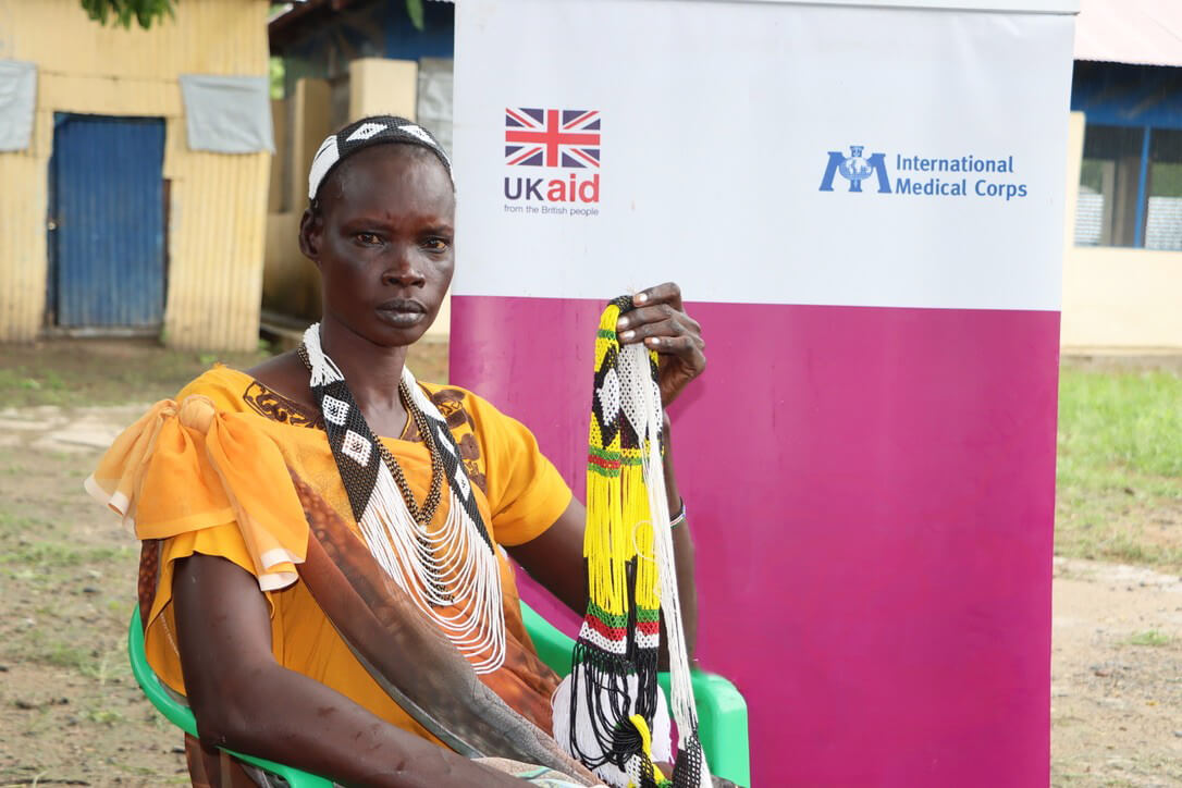 Nyankong Diu wears and holds beading projects that she learned how to make at the WGSS in Malakal.