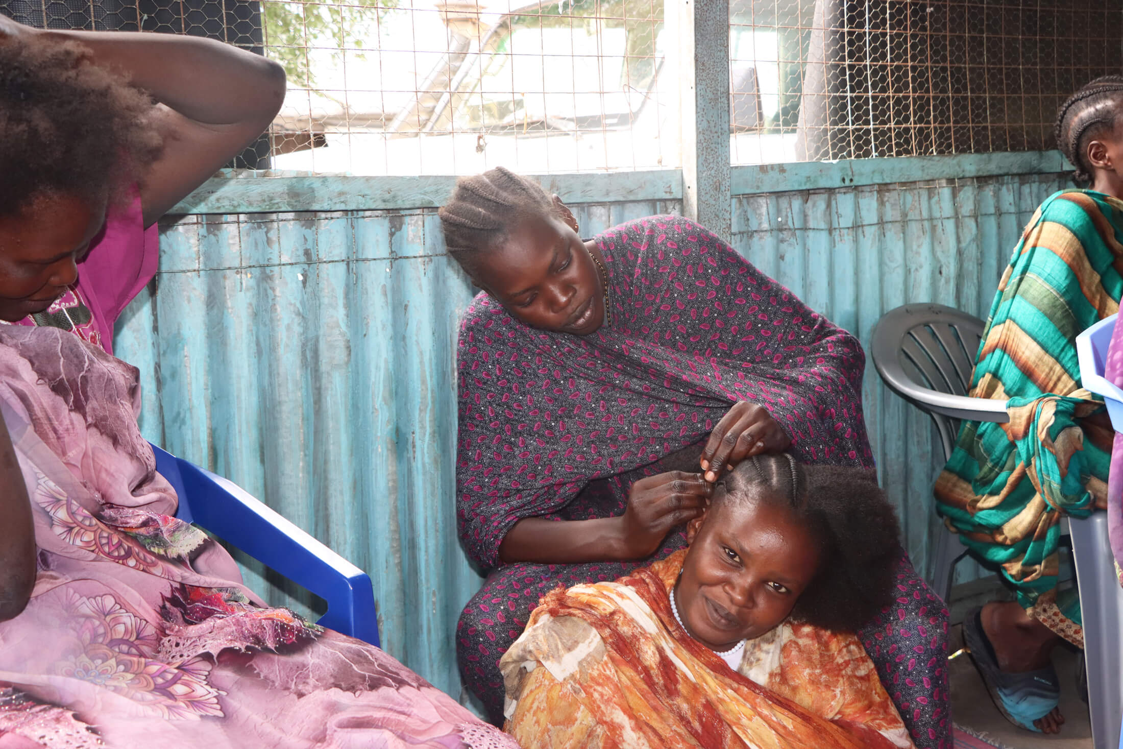 Rebecca William has her hair braided by another woman at the WGSS in Malakal.