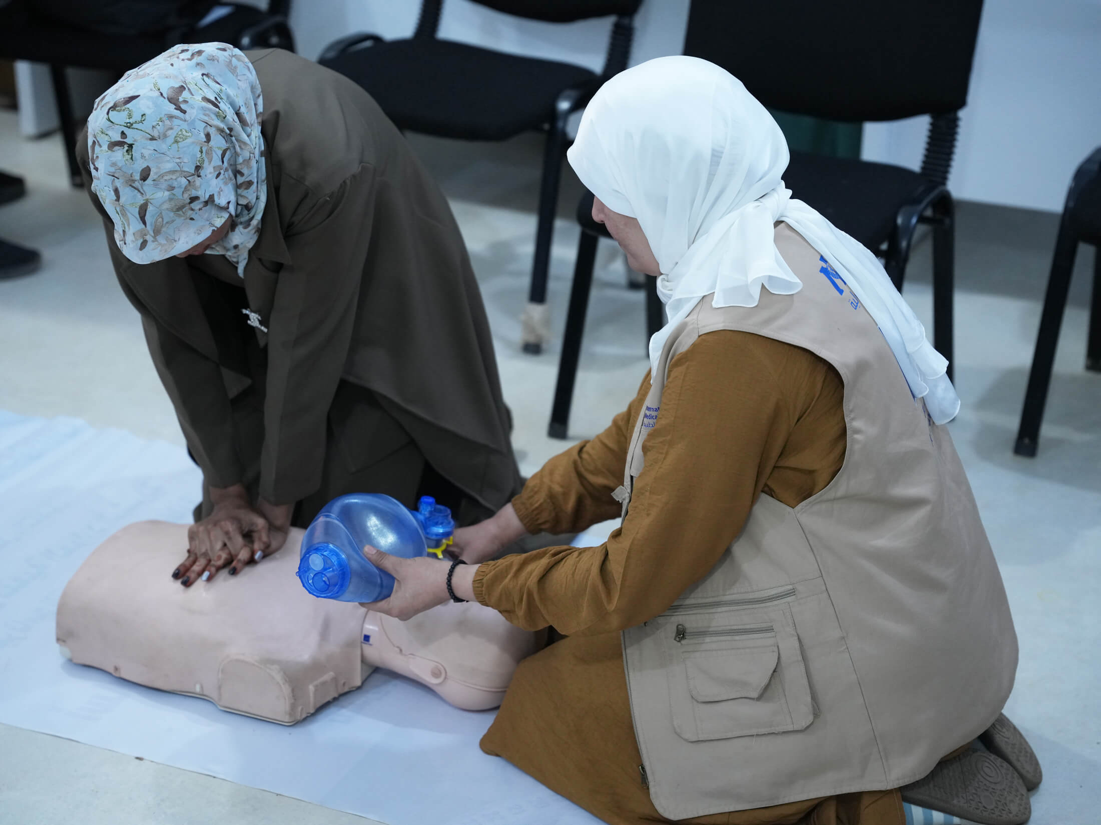 Masouda Bakosh (left) practices CPR, overseen by Hakima Badr, International Medical Corps nurse.