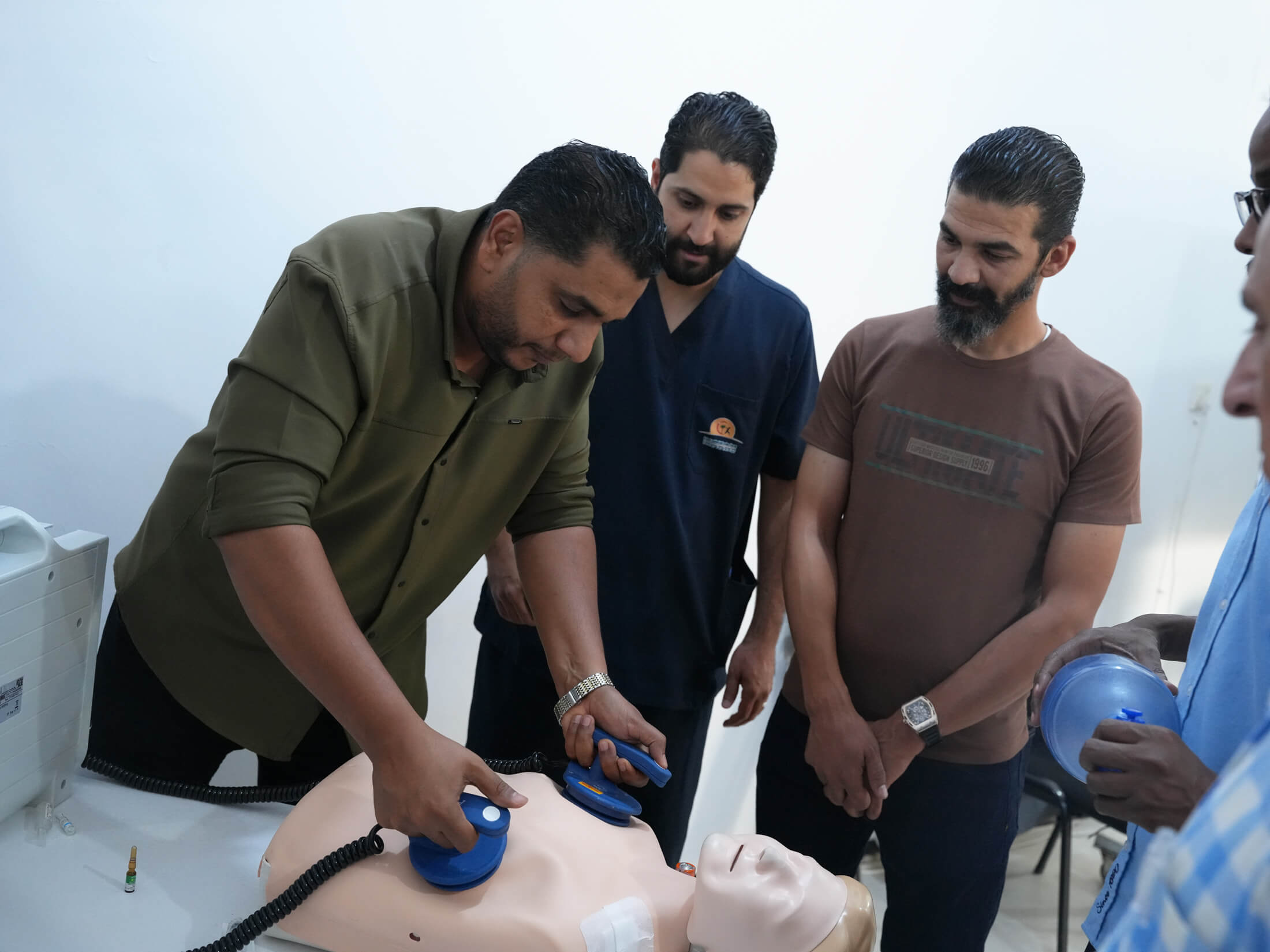 Dr. Jalal practices using an AED during a training session.
