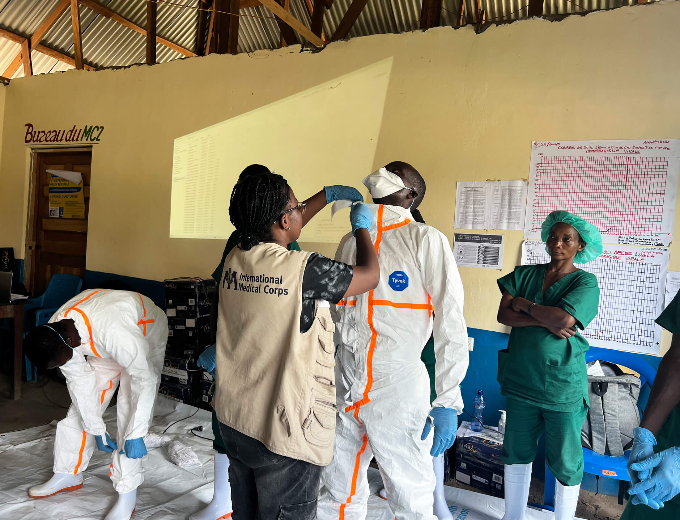Dr. Kashibura Ntakwinja Lina, International Medical Corps’ Medical Team Lead in the DRC, and Dr. Jean Paul Cubaka, Infection Prevention and Control Manager, demonstrate at Ingogo Health Center how to wear PPE.