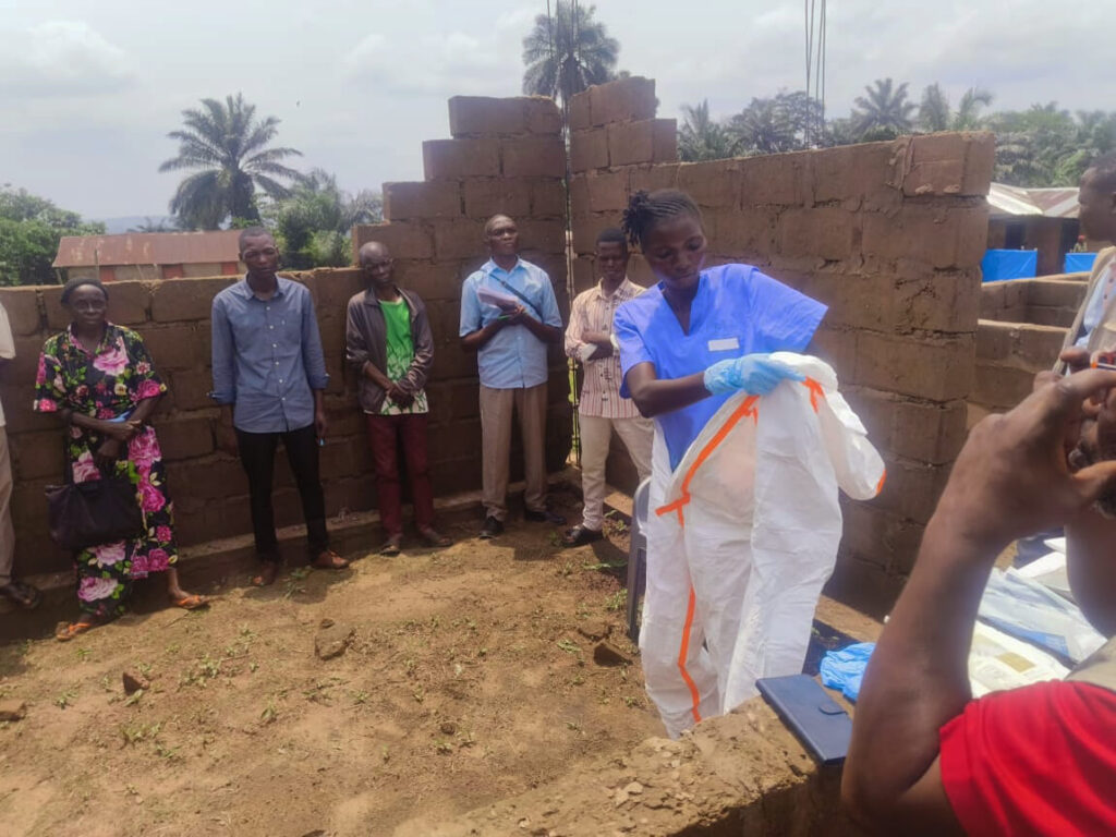 A local health worker puts on personal protective equipment (PPE) at Ingongo Health Center in Kasai province, DRC, where International Medical Corps set up an Ebola screening and referral unit.