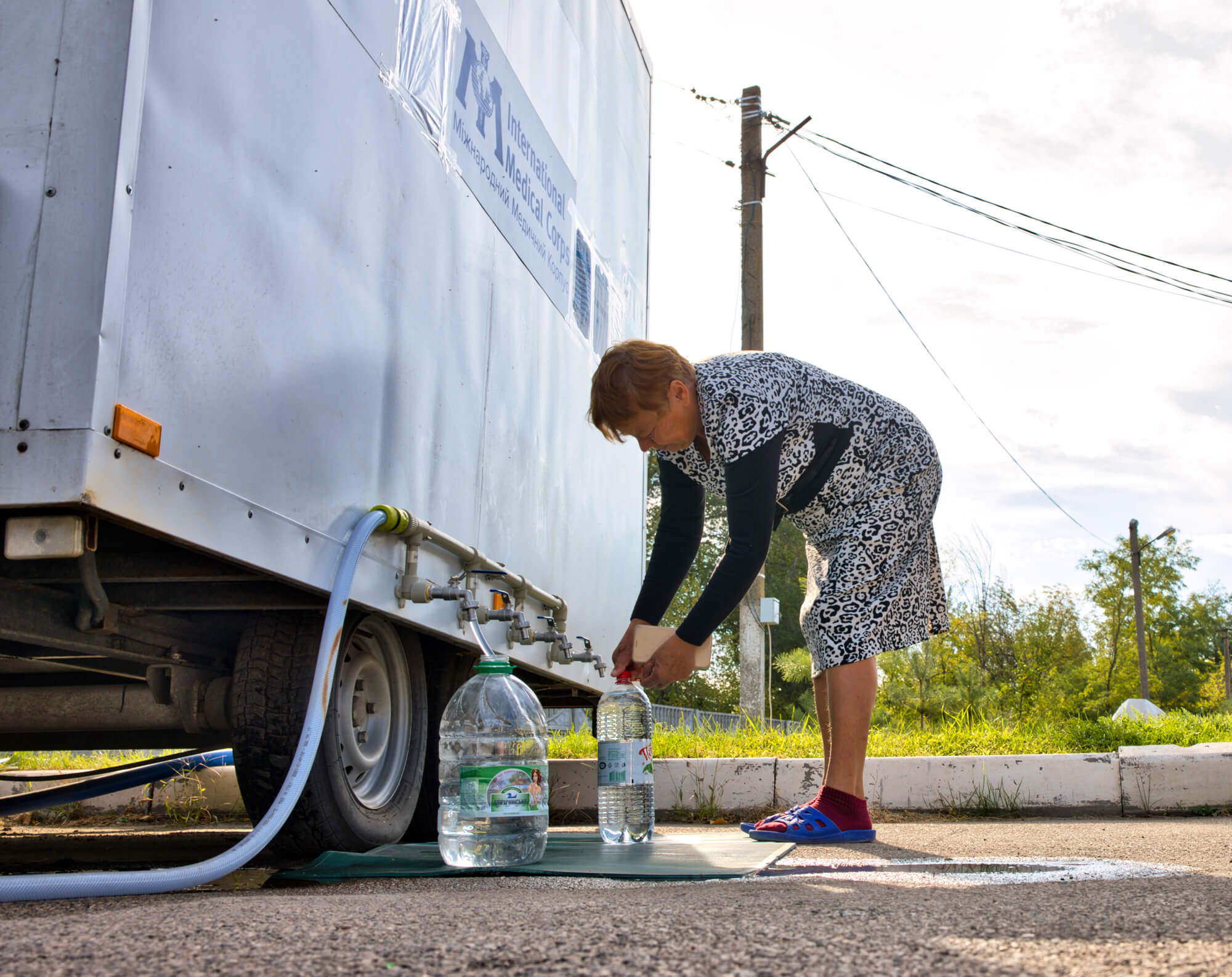 A resident collects clean water from one of our mobile water treatment units in Dnipro.