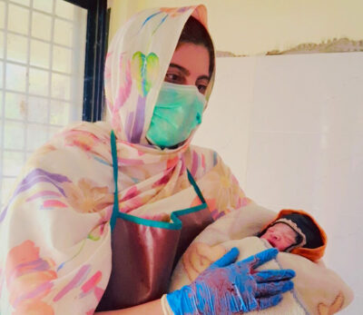 Dr. Nighat Seema holds the healthy newborn after a successful delivery at the BHU in Chagam.