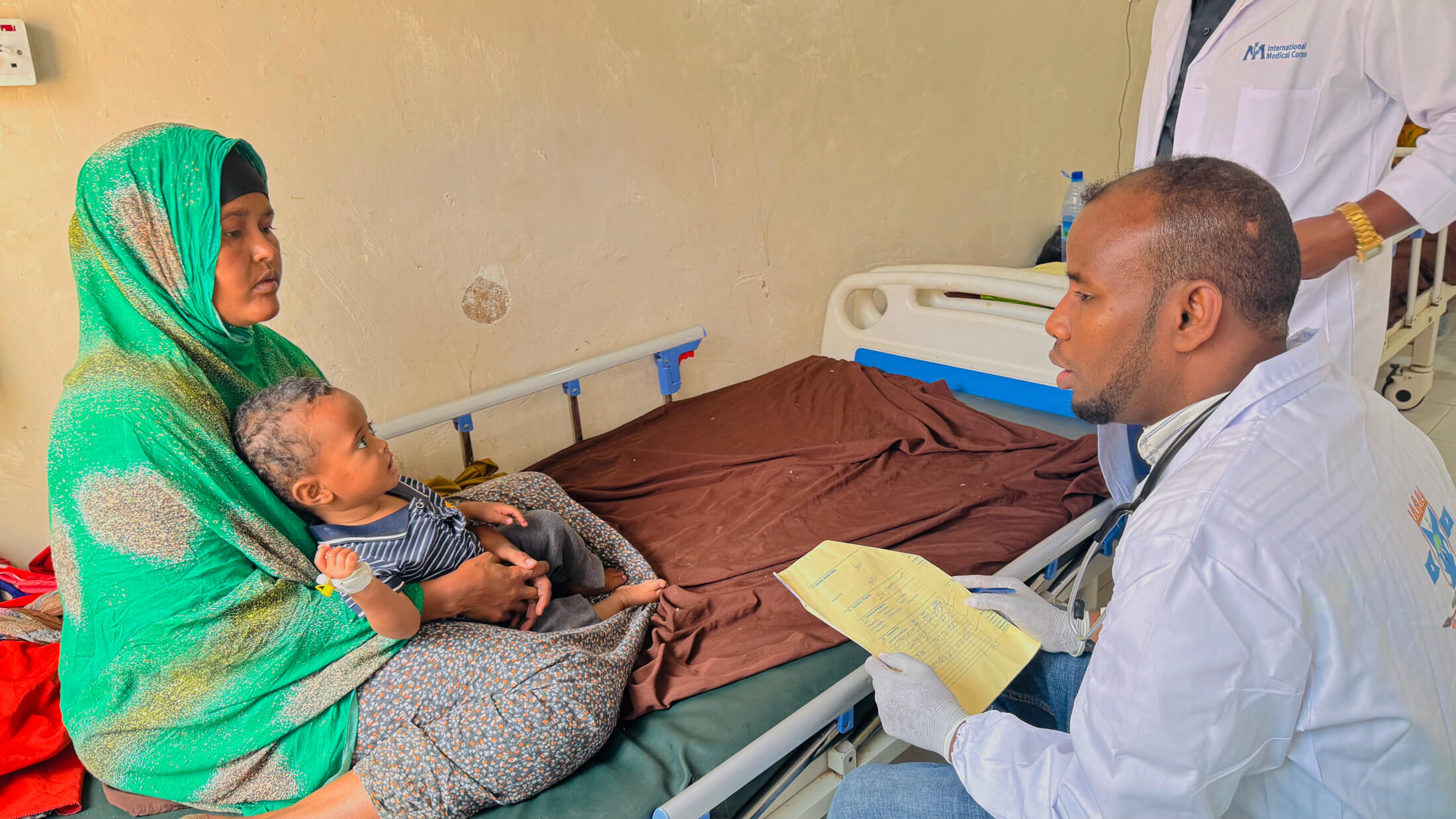 Dr. Bashir Ali Ahmed talks with Shukr Aweys Ahmedi, who has brought her child for treatment at Galkayo South Hospital.