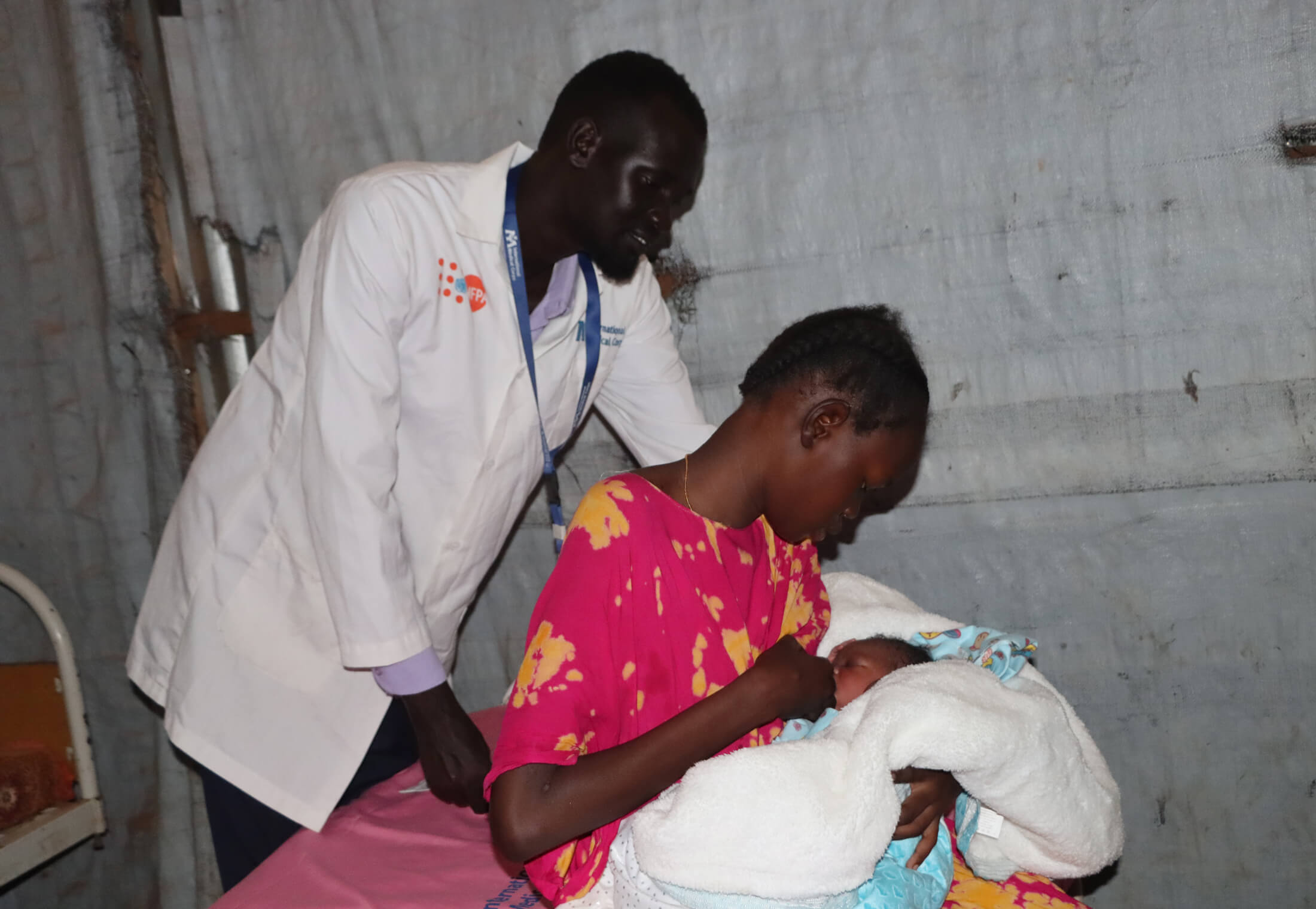 Senior Midwife Supervisor Chuol Ker Yat stands next to Nyachuom and her newborn daughter.