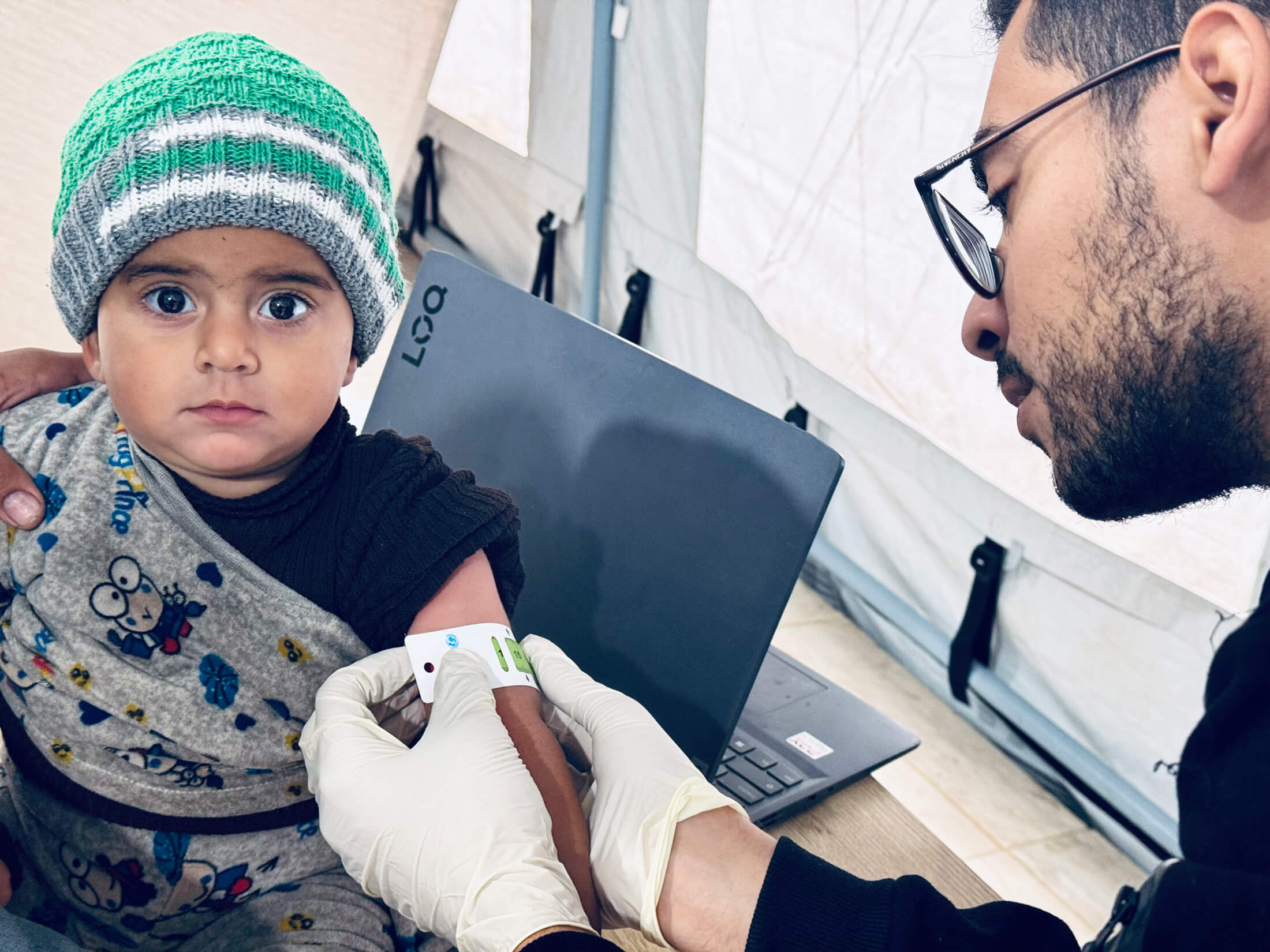 A team member measures a child’s mid-upper arm circumference during our Find and Treat programme at the Deir Al Balah field hospital in Gaza.