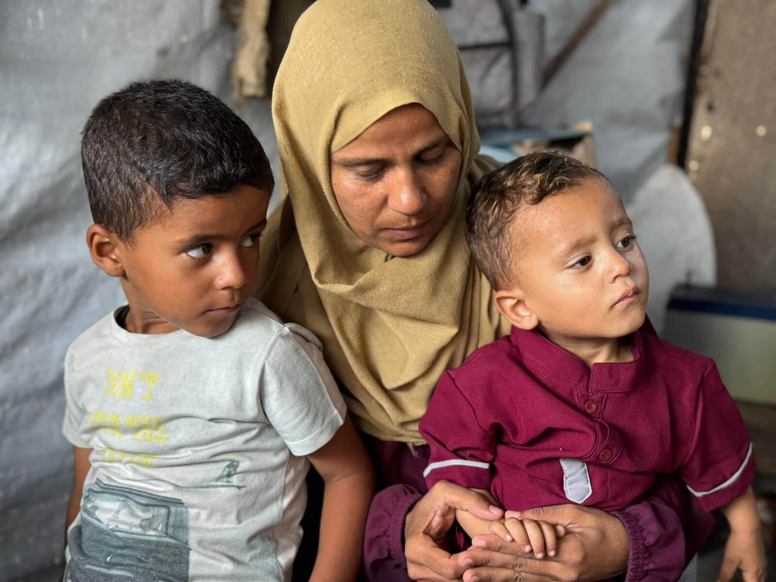 A mother and her children wait to be seen during our Find and Treat nutrition programme at the Deir Al Balah field hospital in Gaza.