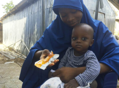 Salamatu feeds Suleiman therapeutic food on the day of his discharge from the TSFP.