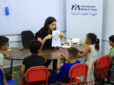 An International Medical Corps Inclusion Officer runs a well-being group session for children.