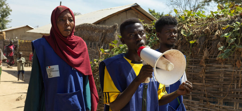 Caption: (Left to right) International Medical Corps staff, Noussaiba Kamiss, Alfati Mahamat and Mahamat conduct community awareness on cholera at Korsi refugee camp, Birao, CAR.
