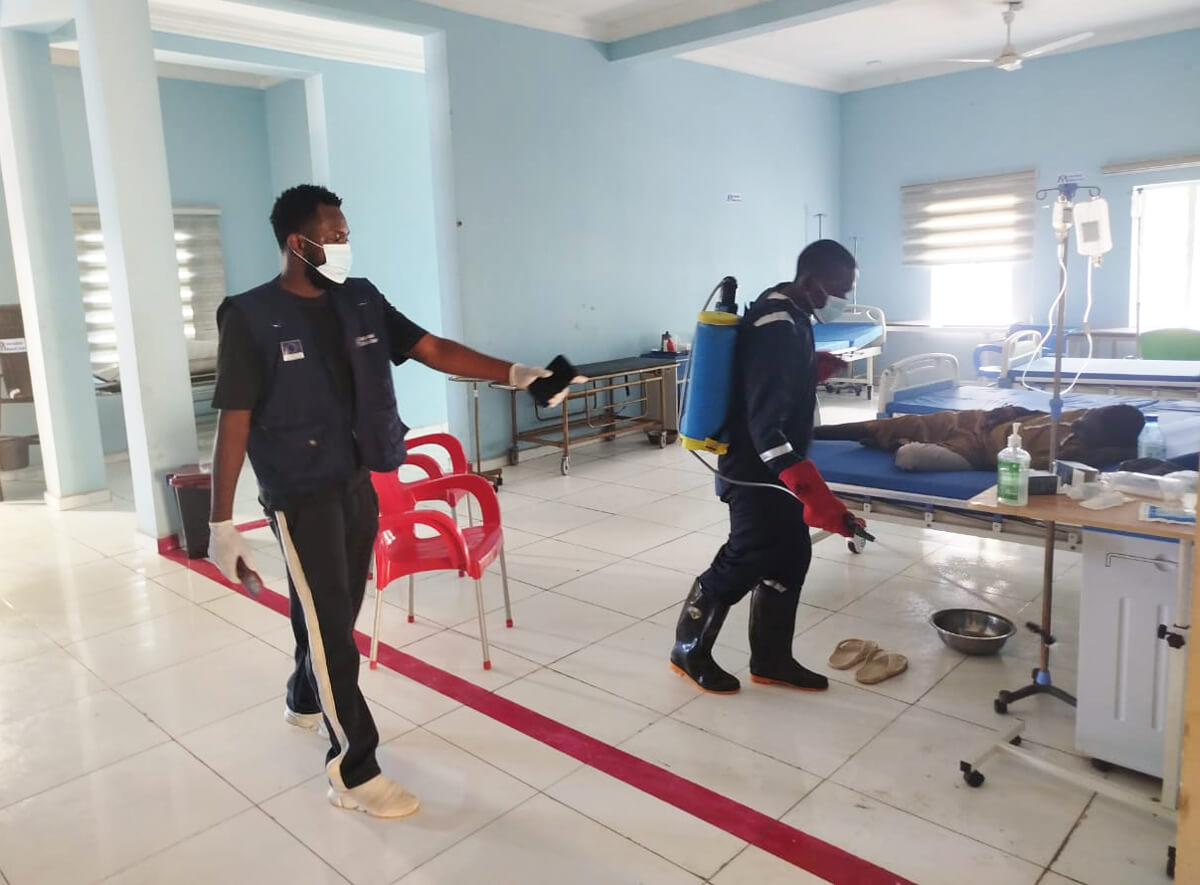 A member of our WASH team directs a Ministry of Health staff member during disinfection of the Damboa general hospital.