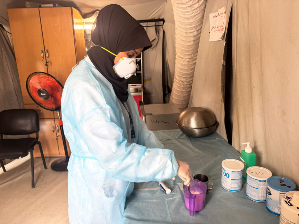 A nutrition specialist prepares a drink for a child with severe malnutrition.
