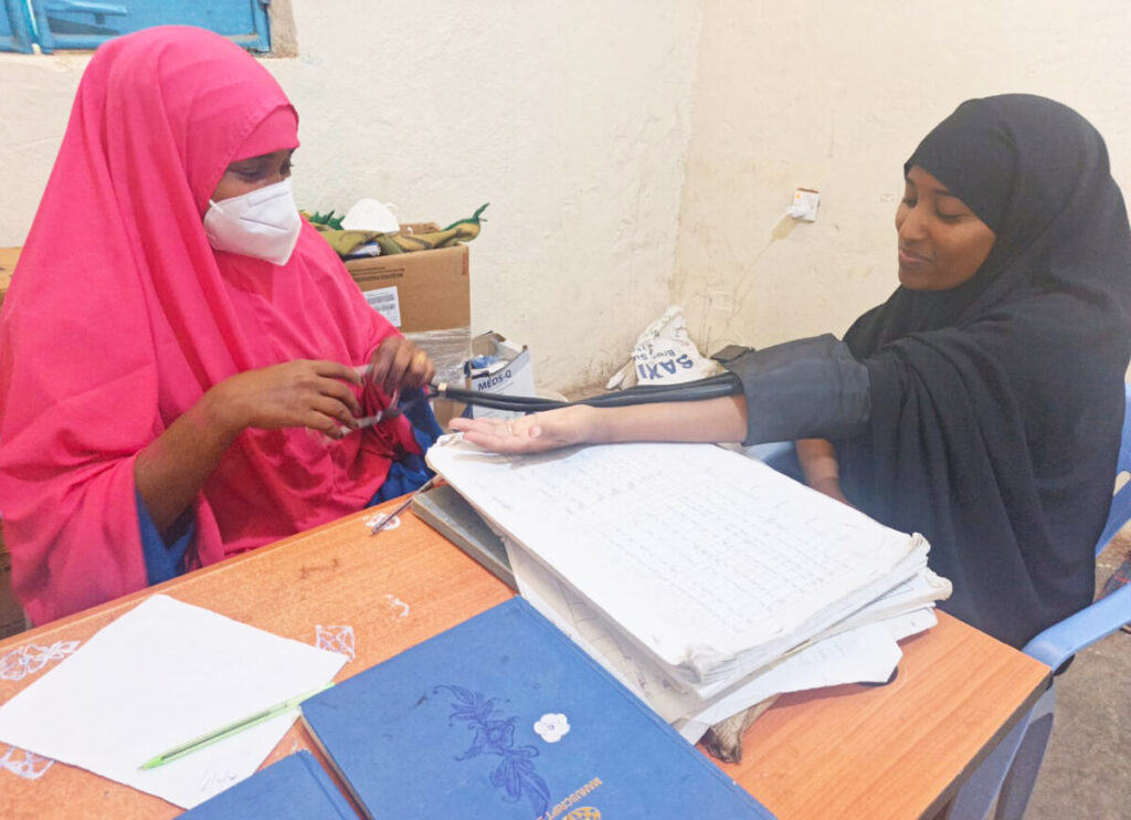 Maryan Ali Mohamed, a midwife at Suuqa Xoolaha Health Center, measures Farhia Ali Adan’s blood pressure during an antenatal care visit.