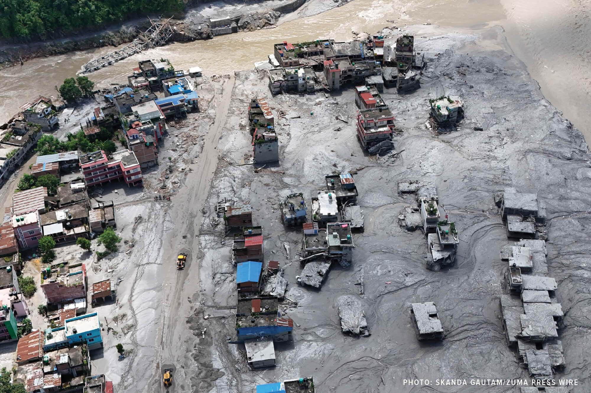 Workers use bulldozers to rebuild the roads following flash floods at Devighat in Bidur municipality, Nuwakot district.