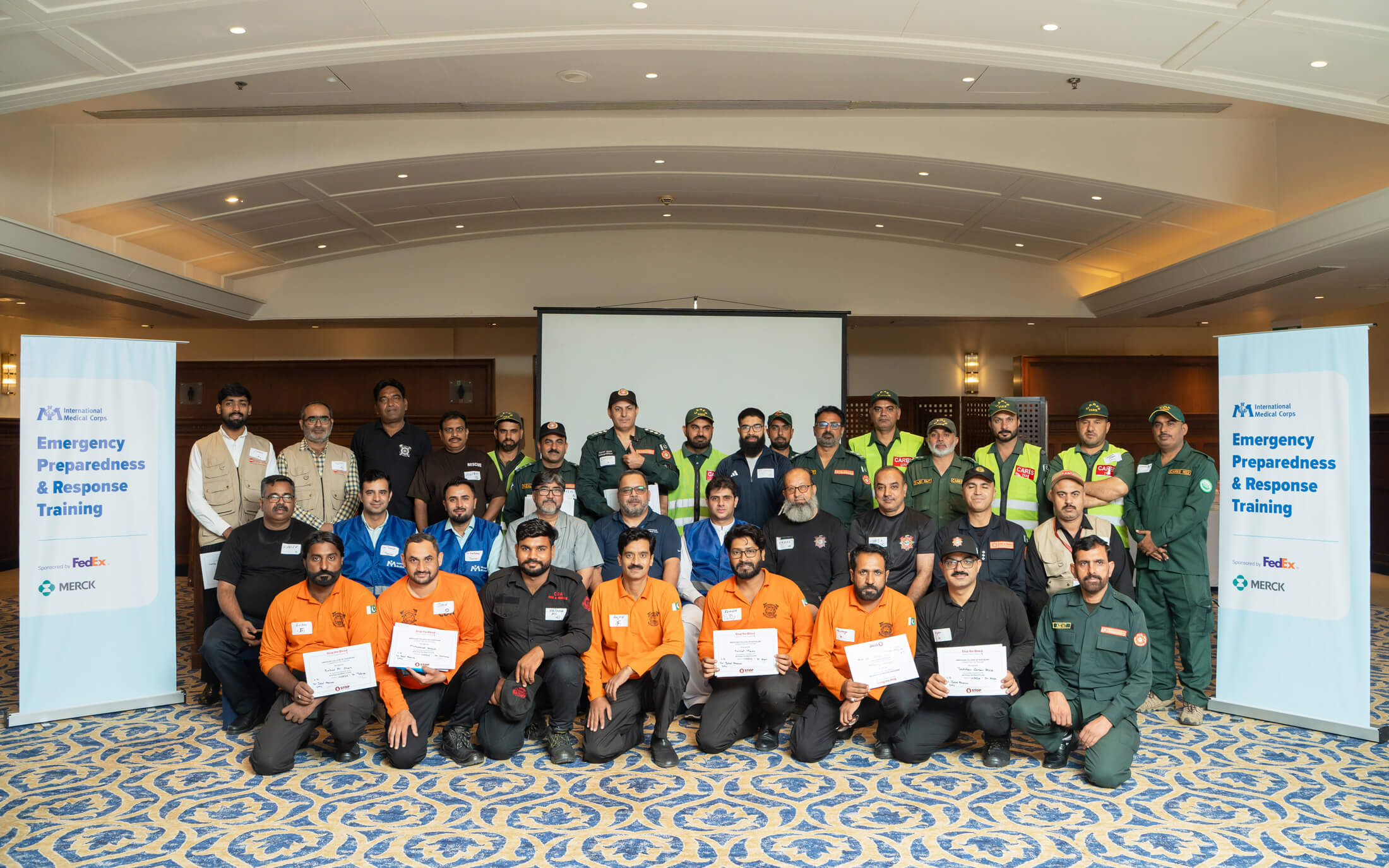 International Medical Corps staff and trainees in Islamabad pose with their BEC training certificates.