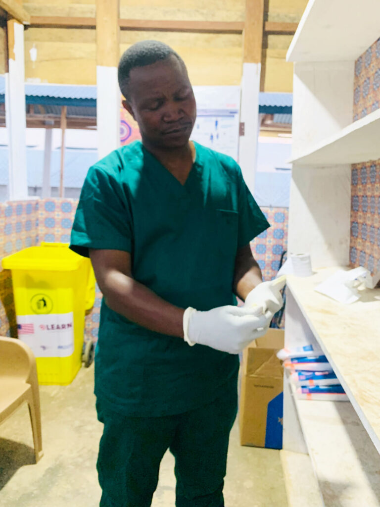Dr. Jean Marie Kashosi puts on gloves as part of the process of preparing to safely enter the Ebola Treatment Center.
