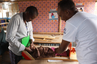 Nutrition team members in Ethiopia measure a child’s height as part of a malnutrition assessment in 2025.