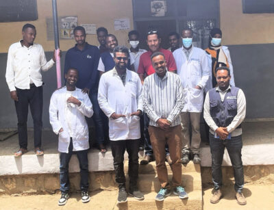 Henock Million (bottom right, in vest) visits an International Medical Corps field team in Oromia region in June 2024.