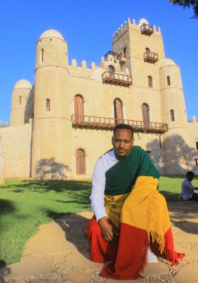 Henock Million wears the Ethiopian flag while kneeling in front of Fasil Ghebbi, a 17th-century fortress in Gondar, where Ethiopian emperors once lived.